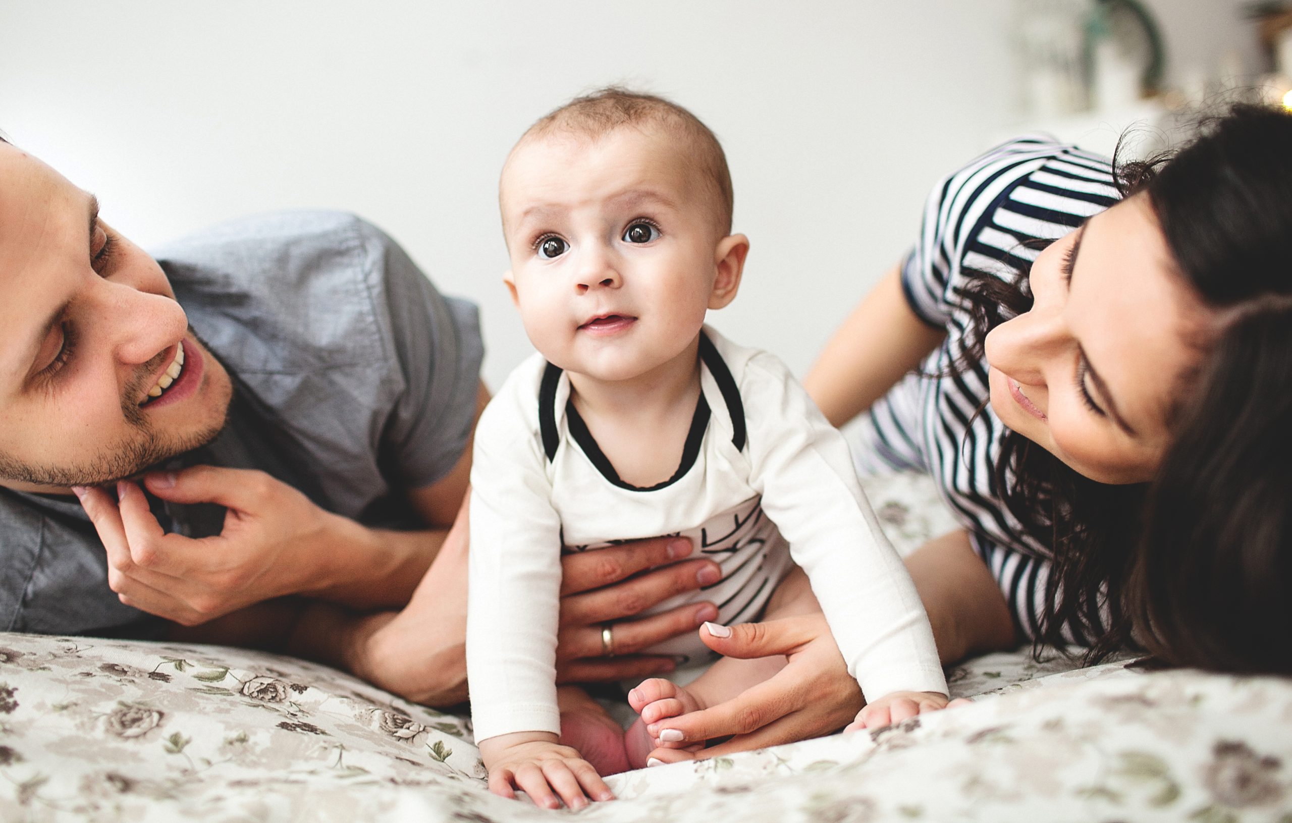 Young parents and their infant share a joyful moment together, a family dream realized.