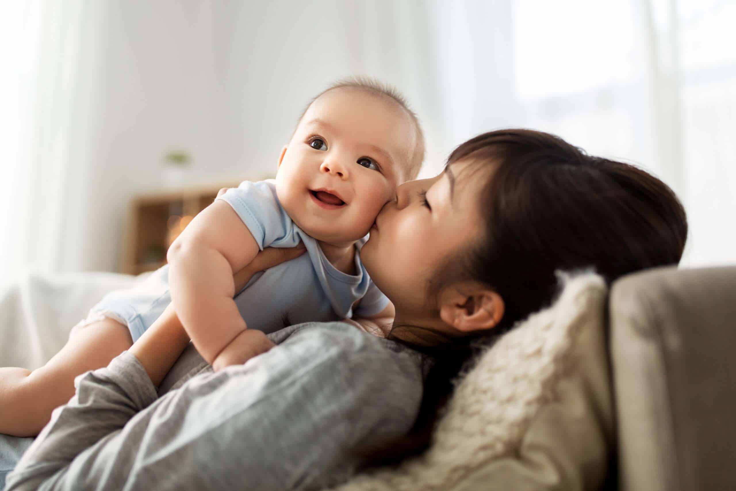 Mother kissing her smiling baby